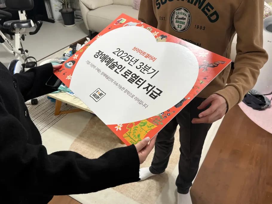 장애예술인 로열티 지급 안내물을 들고 있는 모습